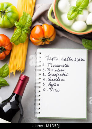 La pasta, il pomodoro, la mozzarella ancora vita sul grigio sfondo rustico. Prodotti tradizionali e cibo lista della spesa per gli spaghetti con i pomodori in italiano Foto Stock