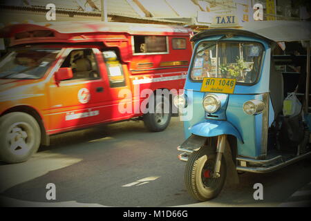 Un blu di tuk-tuk di rosso e un songthaew taxi a Chiang Mai, Thailandia. 24-Gen-2018 Foto Stock