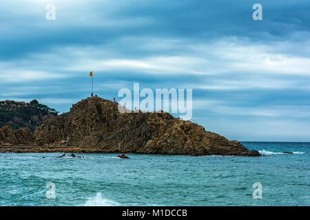 La roccia Sa Palomera con la bandiera nazionale della Spagna in cima (Spagna, Blanes) Foto Stock