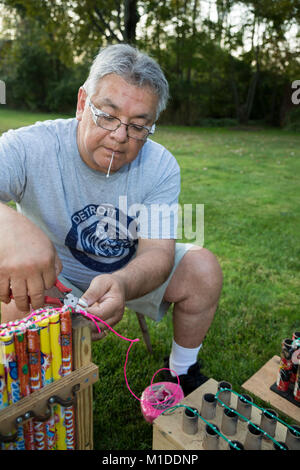 Port Huron Township, Michigan - Lorenzo Almendarez, Suor collega i fusibili per uno spettacolo di fuochi d'artificio nella sua casa. Foto Stock