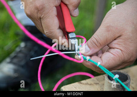 Port Huron Township, Michigan - Lorenzo Almendarez, Suor collega i fusibili per uno spettacolo di fuochi d'artificio nella sua casa. Foto Stock