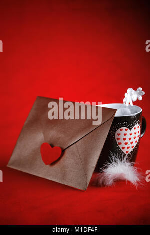 Concetto di san valentino, lettera d'amore, rose e un cuore cup su uno sfondo rosso Foto Stock