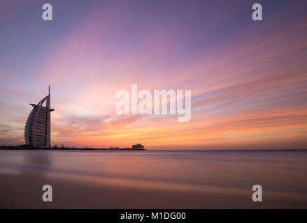 Skyline di Dubai durante un tramonto colorato come visto dalla spiaggia pubblica. Dubai, EAU. Foto Stock