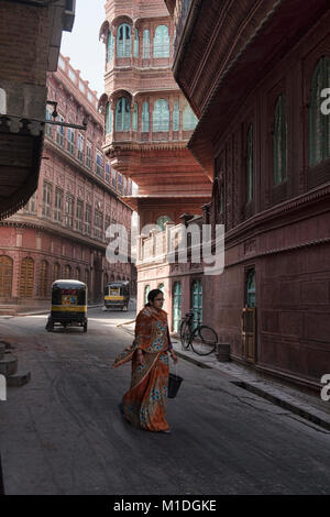 Donna che passa davanti a vecchi haveli case, Bikaner, Rajasthan, India Foto Stock