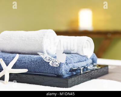 Asciugamani arrotolato su un vassoio sul letto da massaggio spa di bellezza o di un club salute. Foto Stock