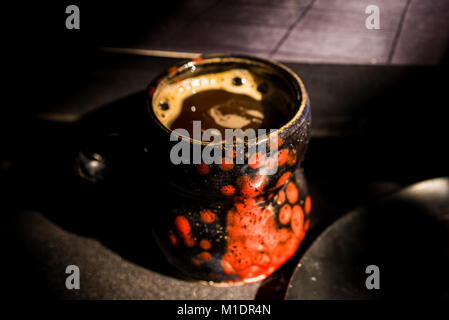 Close up vintage nero e rosso la tazza con il caffè Foto Stock