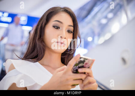 Asia uomini e donne d'affari sono utilizzando mobile e touch smart phone per la comunicazione Foto Stock