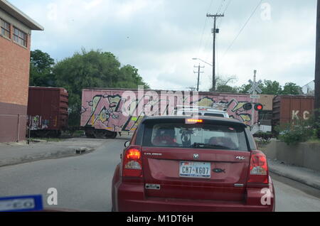 Una coperta di graffiti treno attraversare una strada a san antonio texas Foto Stock