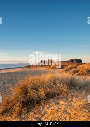 Cabine sulla spiaggia, a Walberwick su un inverni di mattina. Foto Stock