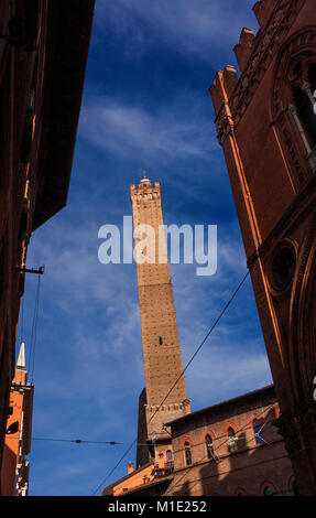 Inclinazione medievale Torre degli Asinelli, la piu' alta torre in Bologna e il simbolo della città, eretto alla fine del XII secolo, visto da una stretta s Foto Stock