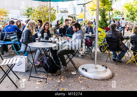 Brooklyn, Stati Uniti d'America - 28 Ottobre 2017: persone folla seduto a mangiare ristorante famoso cibo da bar esterno, Starbucks Coffee di bere Foto Stock