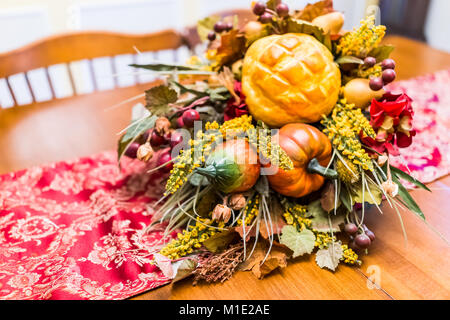 Primo piano di ringraziamento autunno autunno fake cornucopia di decorazione su un tavolo di legno con tovaglia rosso in sala da pranzo Foto Stock