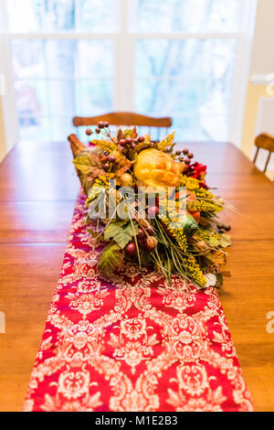 Primo piano di ringraziamento autunno autunno fake cornucopia di decorazione su un tavolo di legno con tovaglia rosso in sala da pranzo Foto Stock