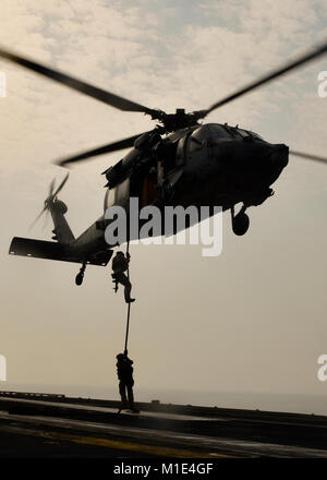 Golfo Arabico (Agosto 22, 2017) DEGLI STATI UNITI Navy esplosivo ordinanza personale di smaltimento partecipano in un fast roping esercizio con un MH-60S Sea Hawk elicottero, dal "Eightballers" di elicottero di mare squadrone di combattimento (HSC) 8, a bordo della portaerei USS Nimitz CVN (68), e il agosto 22, 2017, nel Golfo Arabico. Nimitz è distribuito negli Stati Uniti Quinta Flotta area di operazioni a sostegno di funzionamento inerenti a risolvere. Mentre in questa regione la nave e strike gruppo stanno conducendo le operazioni di sicurezza marittima per rassicurare gli alleati e partner, preservare la libertà di navigazione e di mantenere il flusso libero di commerc Foto Stock