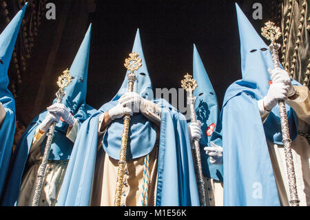 I penitenti della fratellanza di 'San Esteban' in formazione durante l'uscita processionale che porta badge. Foto Stock