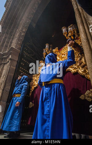 Penitente della fratellanza di 'San Esteban' durante il processionale uscita prossima al galleggiante di Cristo. Foto Stock