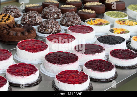 Torta e linea di cottura.una linea industriale di torte. Molte belle torte sul tavolo.multicolore prodotti culinari Foto Stock