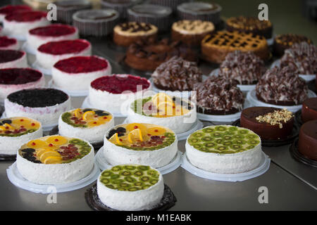 Torta e linea di cottura.una linea industriale di torte. Molte belle torte sul tavolo.multicolore prodotti culinari Foto Stock