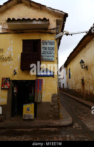 Shlomi segno ostello in ebraico per backpackers israeliano su edificio coloniale con mini market shop, Cusco, Perù Foto Stock