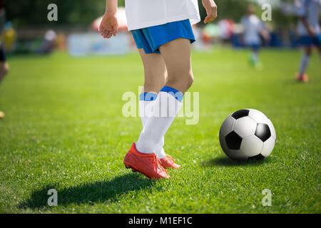 Piedi del giocatore di calcio con pallone da calcio. I giocatori di calcio prima di kick pass per il compagno di squadra Foto Stock