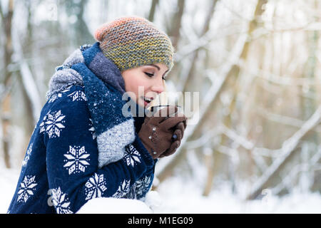 La donna il congelamento in una fredda giornata invernale il riscaldamento se stessa fino a caldo con Foto Stock