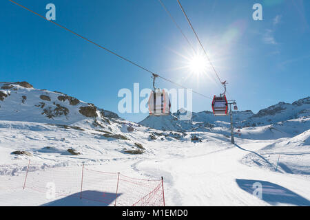 La funivia sollevare il cavo auto, gondola cabine in inverno le montagne innevate sullo sfondo lo splendido paesaggio. Foto Stock