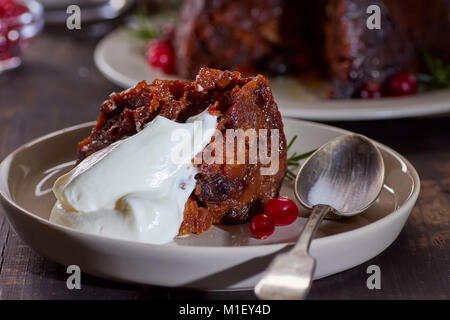 Pezzo di pudding natalizio con panna montata Foto Stock