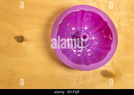 Viola la cottura in silicone coppe per muffin o tortine su legno solido background. Vista dall'alto. Foto Stock