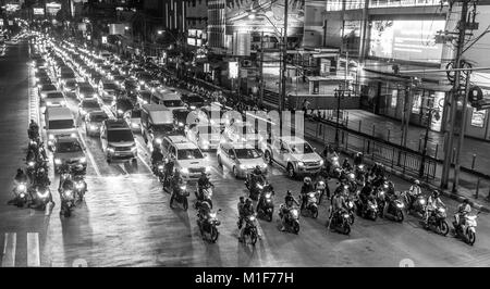 Bangkok, Thailandia Dicembre 2017: una immagine in bianco e nero di motocicli e automobili in attesa in corrispondenza di una giunzione di occupato sulla Strada di Sukhumvit Road di notte a Bangkok. Foto Stock