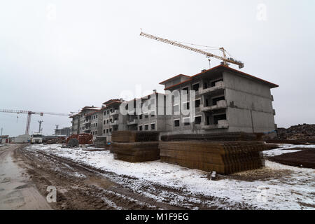 Gru a torre lavorando su un sito in costruzione, la costruzione di una casa, gru a torre contro il cielo, macchinari per la costruzione di casa di costruzione Foto Stock