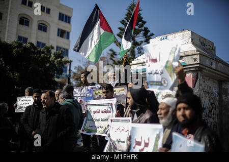 La striscia di Gaza City, nella Striscia di Gaza. 30 gen, 2018. Le persone in attesa di banner e bandiere di onda della Palestina durante una marcia organizzata da parte delle fazioni palestinesi in occasione della Giornata internazionale di solidarietà con il popolo palestinese nella Striscia di Gaza City, nella Striscia di Gaza, 30 gennaio 2018. Credito: Mohammed Talatene/dpa/Alamy Live News Foto Stock