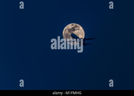 New Delhi, India. 30 gen, 2018. Un aereo appare nella parte anteriore del magnifico super-luna un giorno prima dell'eclisse lunare. Credito: Swapan Banik/Alamy Live News Foto Stock