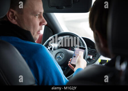 Praga, Repubblica Ceca - 21.01.1018: l'uomo utilizzando smart phone in auto durante la guida Foto Stock