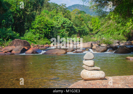 Vicino la pila di ciottoli con bella vista del paesaggio di piccole cascate del fiume con un flusso di acqua che fluisce attraverso la pietra. Foto Stock