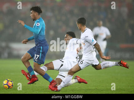 Arsenal Alex Iwobi (sinistra) che fugge da Swansea City è Kyle Naughton (destra) e Martin Olsson durante il match di Premier League al Liberty Stadium, Swansea. Foto Stock