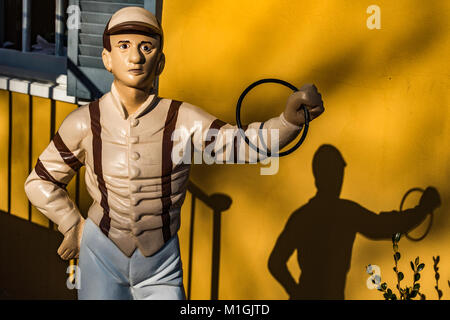 Stile antico Lawn Jockey di fronte all'ingresso del negozio. Foto Stock