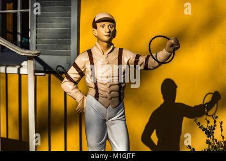 Stile antico Lawn Jockey di fronte all'ingresso del negozio. Foto Stock