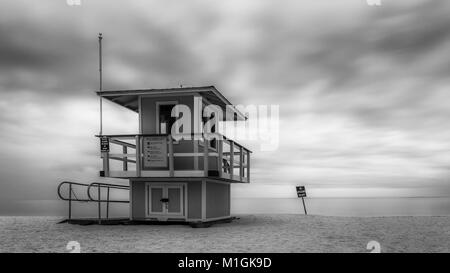 Torre bagnino sulla spiaggia di sabbia durante il tempestoso giorno nuvoloso Foto Stock