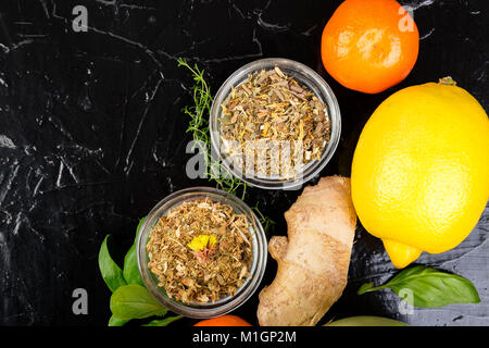 Concetto di medicina naturale. Rimedi naturali per il raffreddore su sfondo nero. Lay piatto. Copia dello spazio. Foto Stock