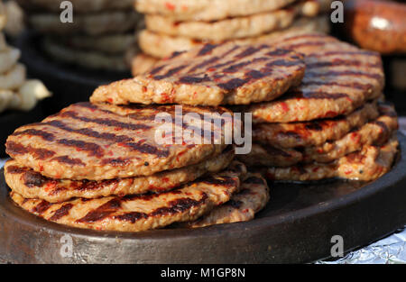 In casa le polpette di carne alla griglia. Grill sfondo. Piede veloce all'esterno. La dieta e la salute. Carni macinate sul barbecue. Pleskavitsa, pleskavitza, pleskavica Foto Stock