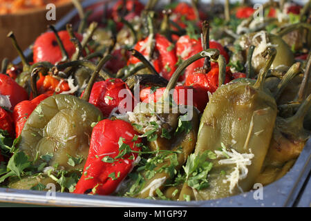 Arrosto peperoni spellati per insalata in un giorno. Rosso e verde peperoni spellati con aglio e prezzemolo. Cibo sano. Insalata. Foto Stock