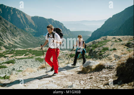 L uomo e la donna il nordic walking in Alti Tatra su un luminoso giorno. Foto Stock