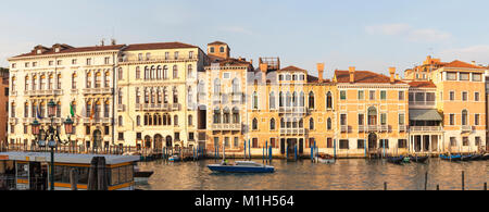 Panorama di palazzi sul Canal Grande, San Marco, Venezia, Veneto, Italia al tramonto nella luce dorata con la salute Fermata del Vaporetto in foregro Foto Stock