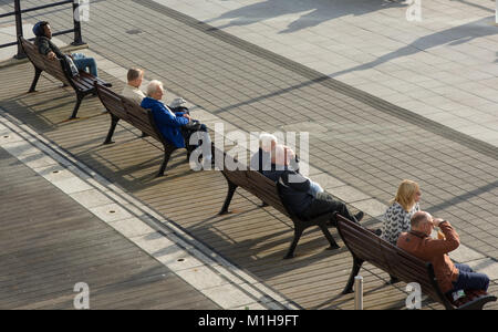 Gunwharf Quays shopping mall a Portsmouth, Hampshire, Inghilterra. Persone sedute sulle panchine da marina. Foto Stock