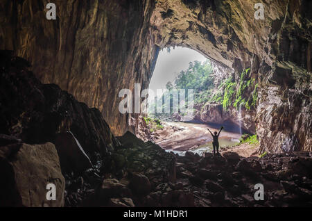 Un turista con le braccia aperte in un magnifico appendere en swallow nella grotta di phong nha ke bang national park, Vietnam Foto Stock