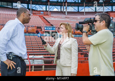 Miami Florida,Orange Bowl,donne ispaniche donne femminili,giornalista,reporter,media,intervista,interviste,uomo nero uomini maschio,stadio di calcio demolizione pr Foto Stock