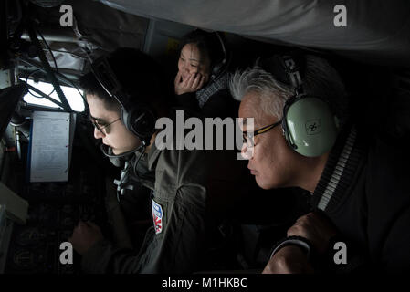 Stati Uniti Air Force Staff Sgt. Possibilità Italiano, 909th Air Refuelling Squadron KC-135 Stratotanker boom operatore, Kazumi Kaneshiro, Presidente di Lions Club e Noriyasu Shimabukuro, Vice Presidente Okinawa della Camera di Commercio e Industria di condurre un comandante onorario volo di orientamento 11 gennaio 2018 sull'Oceano Pacifico. Il volo enhanced leader civili' comprensione di Kadena's operazioni con esperienza di prima mano di air-air refuelling e incontro con 909th ARS leader. (U.S. Air Force Foto Stock