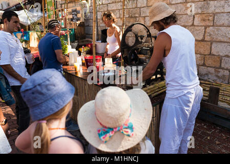 L'uomo premendo la canna da zucchero ad un mojito bar presso la Fira d'Indiani in Begur, Spagna Foto Stock