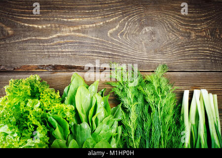 Fresche foglie di lattuga, cipolla e finocchio su uno sfondo di legno Foto Stock