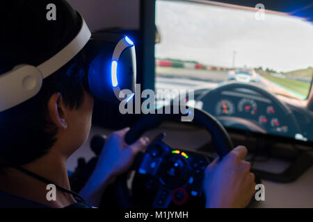 Riproduzione di video racing game con auricolare VR a casa Foto Stock